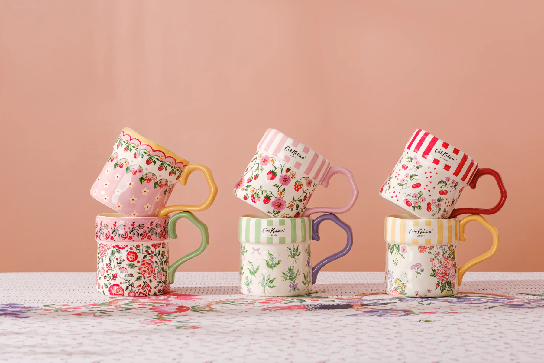 Six Cath Kidston mugs with floral patterns and colored handles